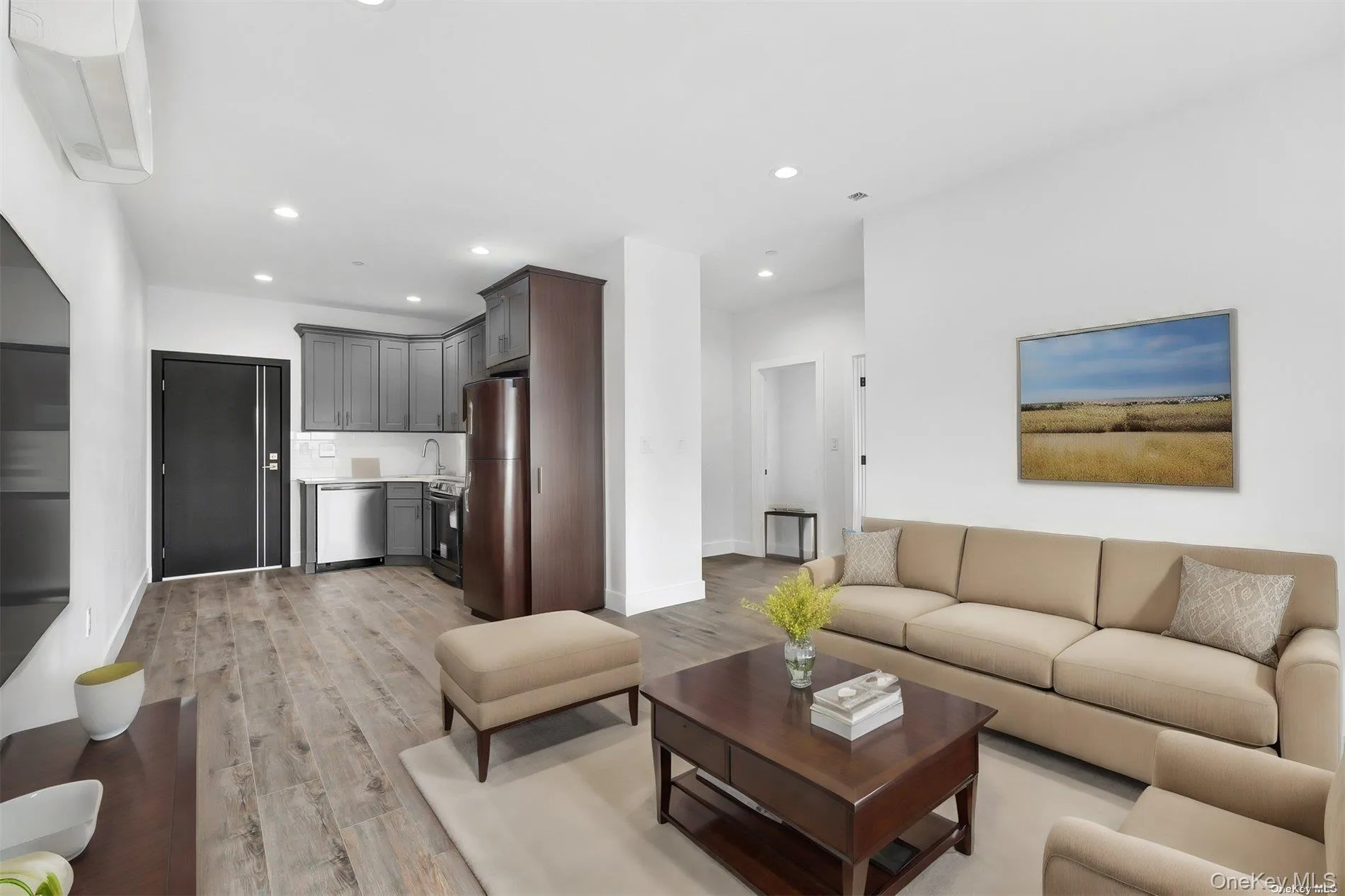 Living room with recessed lighting, light wood-type flooring, and an AC wall unit Living room with recessed lighting, light wood-type flooring, and an AC wall unit