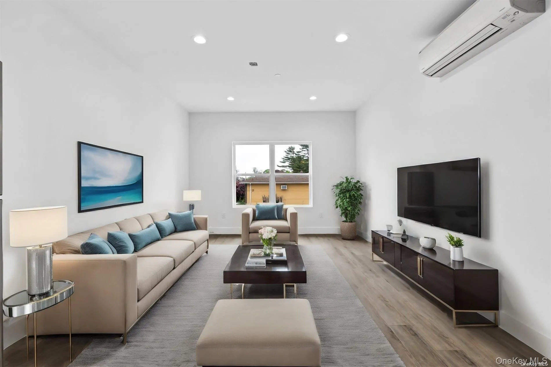 Living area featuring a wall mounted air conditioner, recessed lighting, and light wood finished floors Living area featuring a wall mounted air conditioner, recessed lighting, and light wood finished floors
