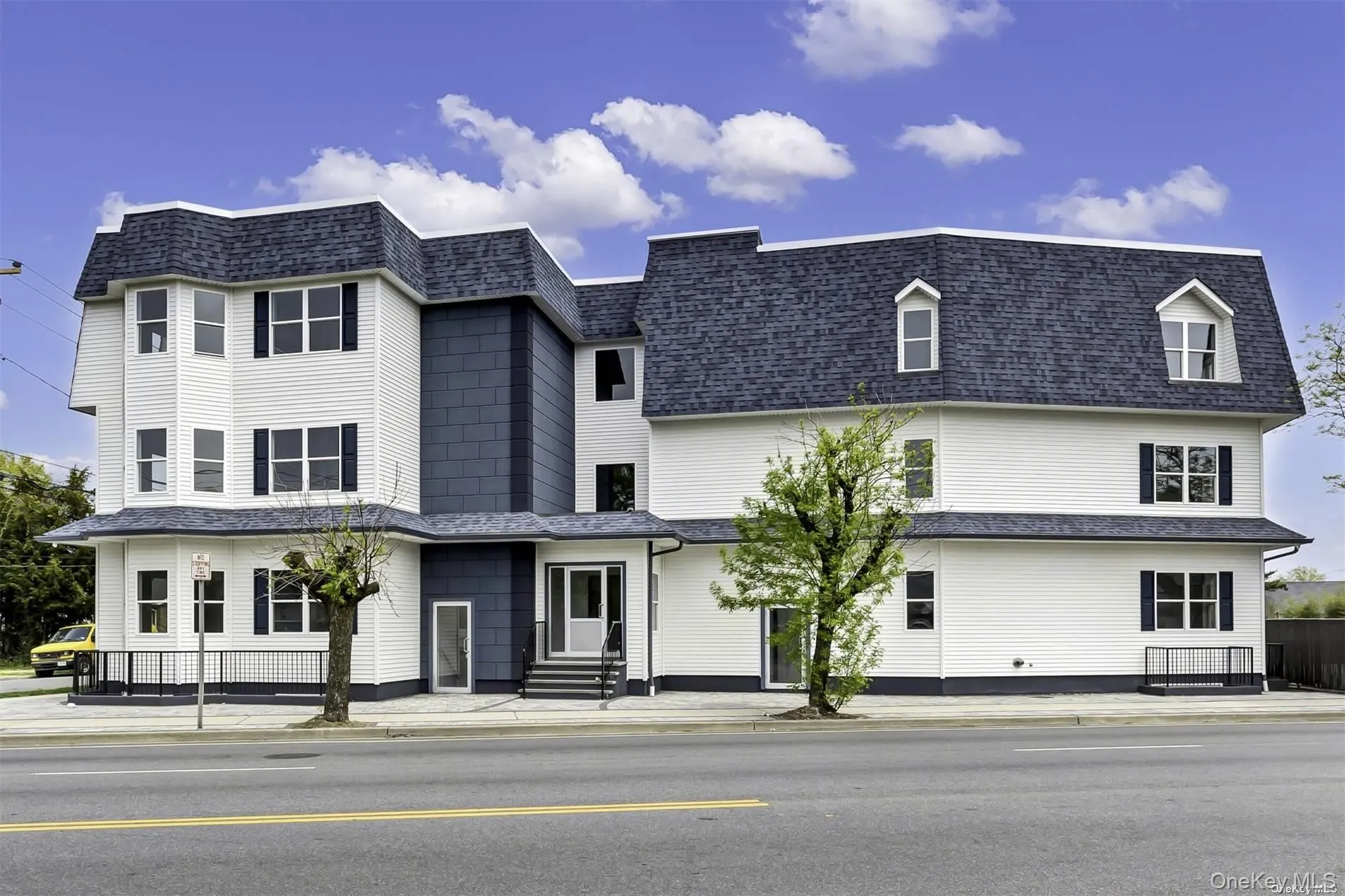 View of front of home with mansard roof and a shingled roof View of front of home with mansard roof and a shingled roof