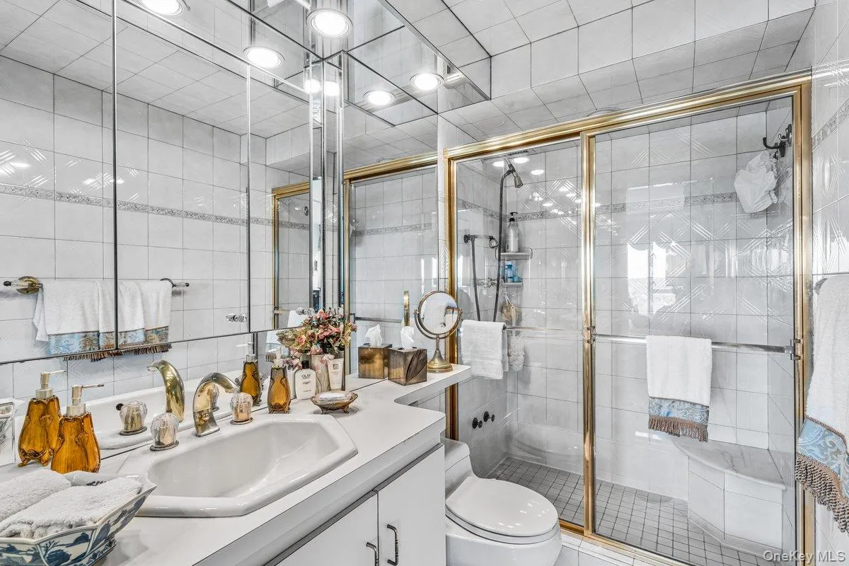 Full bathroom with tile walls, vanity, and a stall shower Full bathroom with tile walls, vanity, and a stall shower