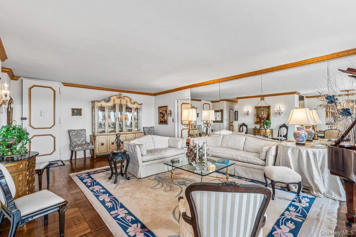 Living room featuring ornamental molding and a chandelier Living room featuring ornamental molding and a chandelier