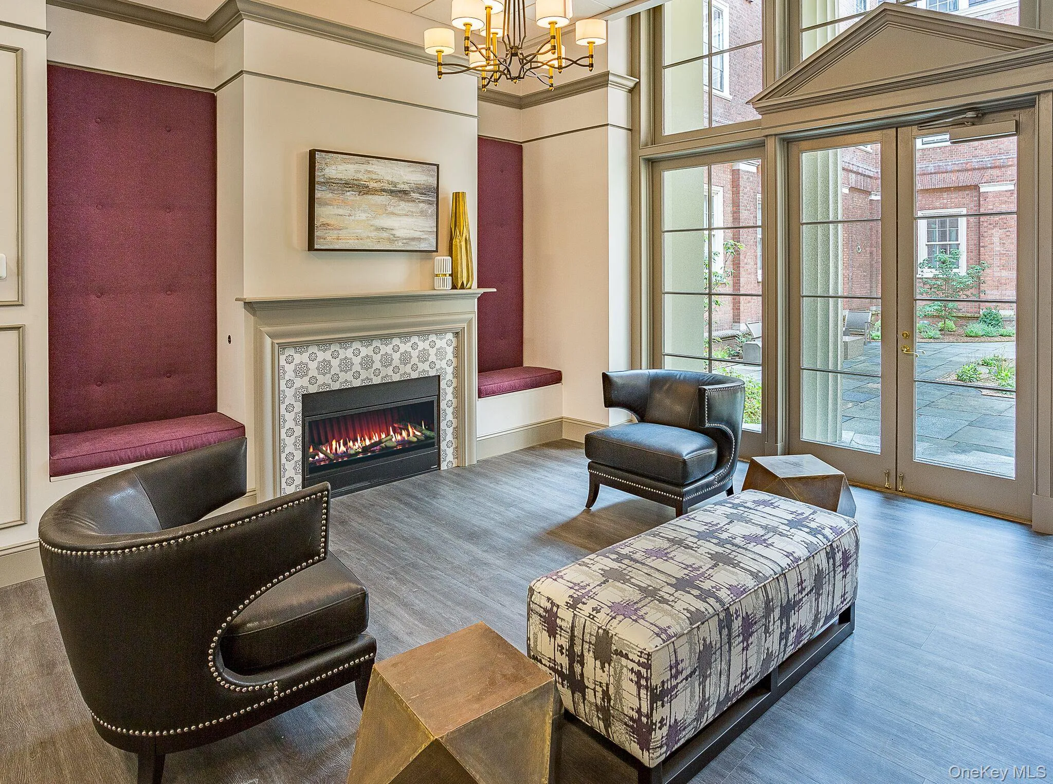 Living room featuring wood finished floors, a fireplace, ornamental molding, a chandelier, and a high ceiling Living room featuring wood finished floors, a fireplace, ornamental molding, a chandelier, and a high ceiling