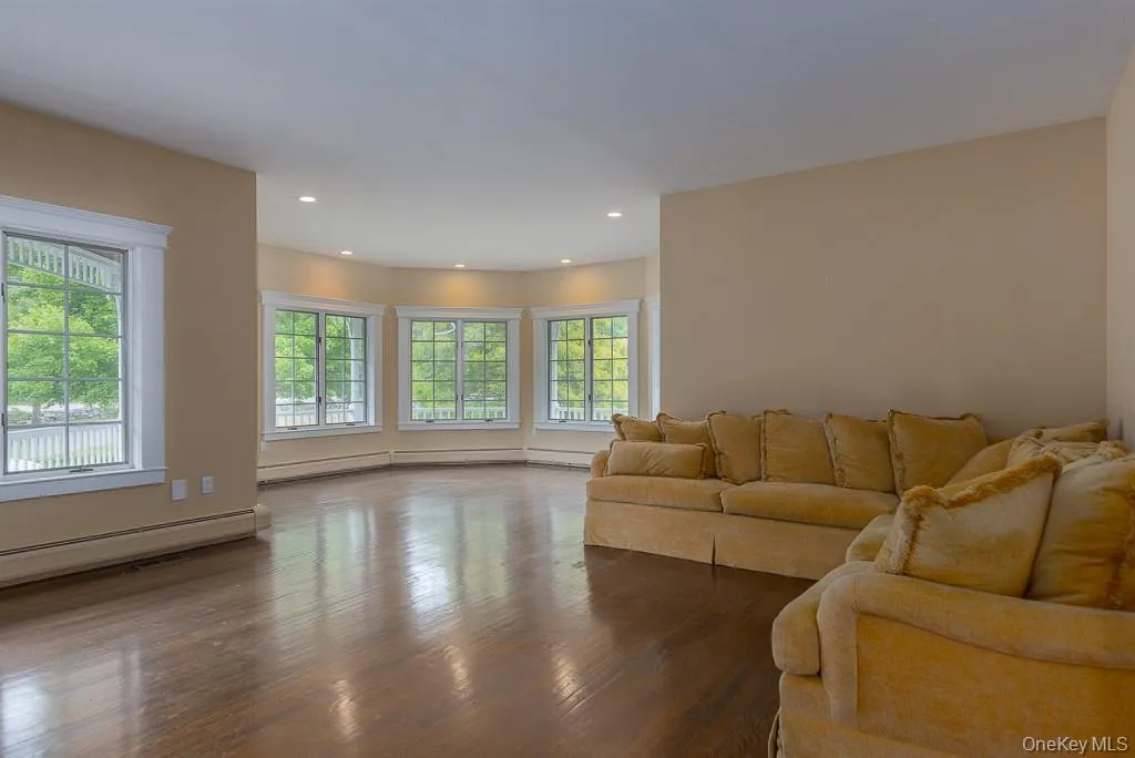 Living area with wood finished floors, recessed lighting, and a baseboard radiator Living area with wood finished floors, recessed lighting, and a baseboard radiator