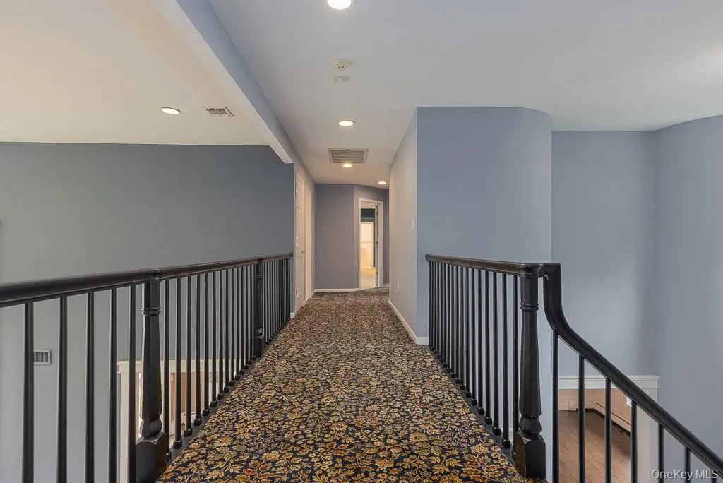 Corridor featuring an upstairs landing and recessed lighting Corridor featuring an upstairs landing and recessed lighting