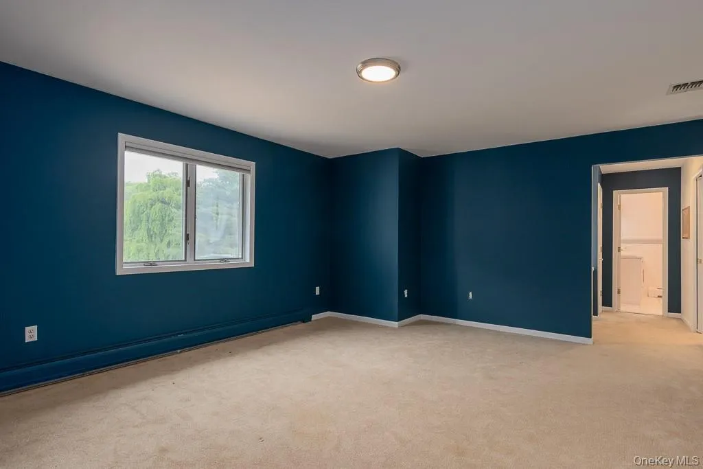 Spare room featuring light carpet and baseboards Spare room featuring light carpet and baseboards