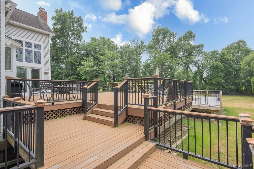 Wooden deck with a lawn and view of scattered trees Wooden deck with a lawn and view of scattered trees