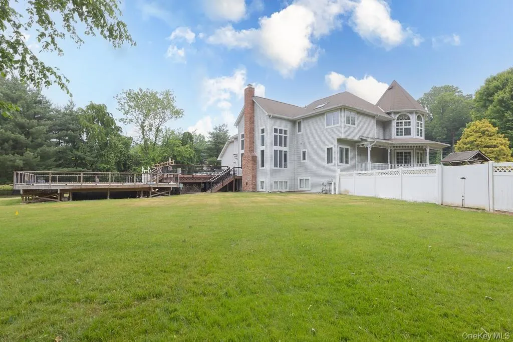 Rear view of property featuring a chimney and a wooden deck Rear view of property featuring a chimney and a wooden deck