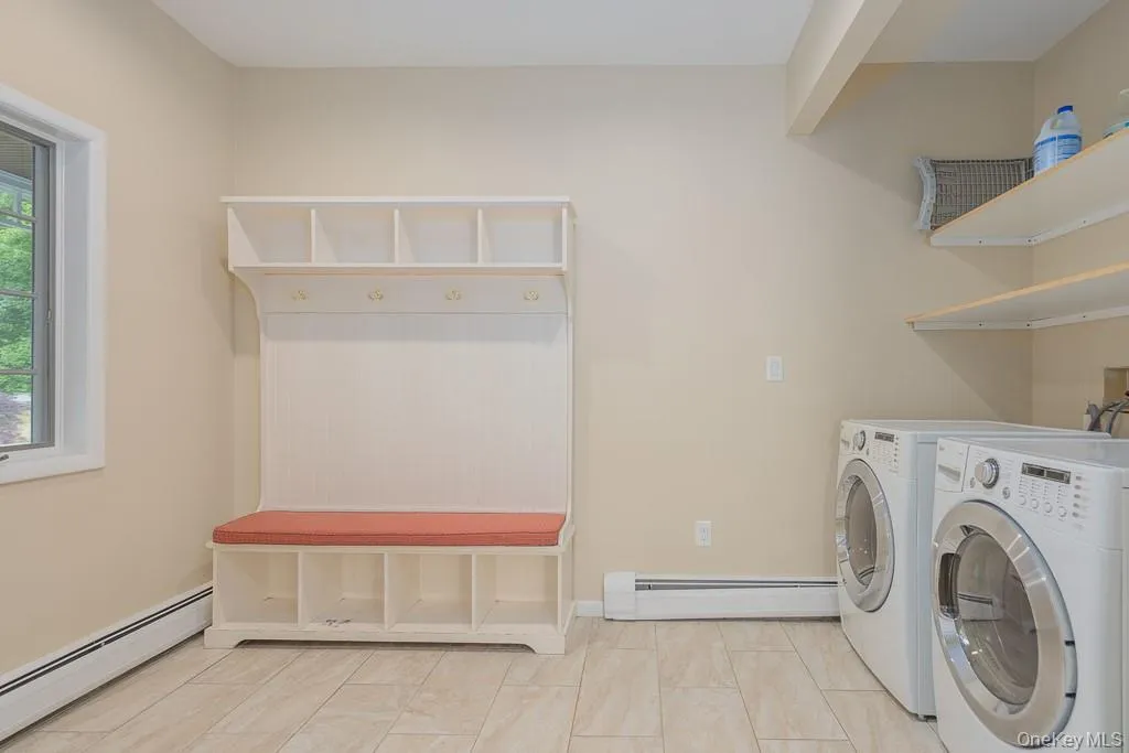 Laundry room featuring a baseboard heating unit and washing machine and clothes dryer Laundry room featuring a baseboard heating unit and washing machine and clothes dryer