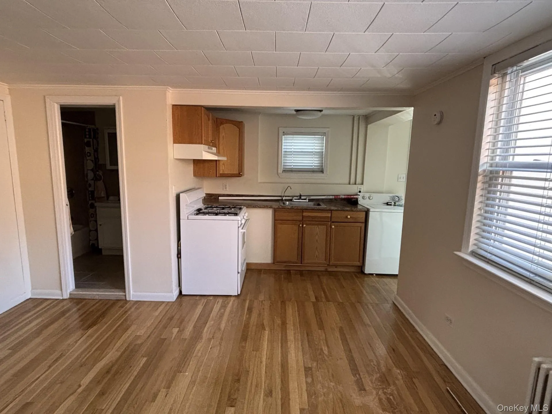 Kitchen with brown cabinetry, plenty of natural light, dark countertops, and crown molding Kitchen with brown cabinetry, plenty of natural light, dark countertops, and crown molding