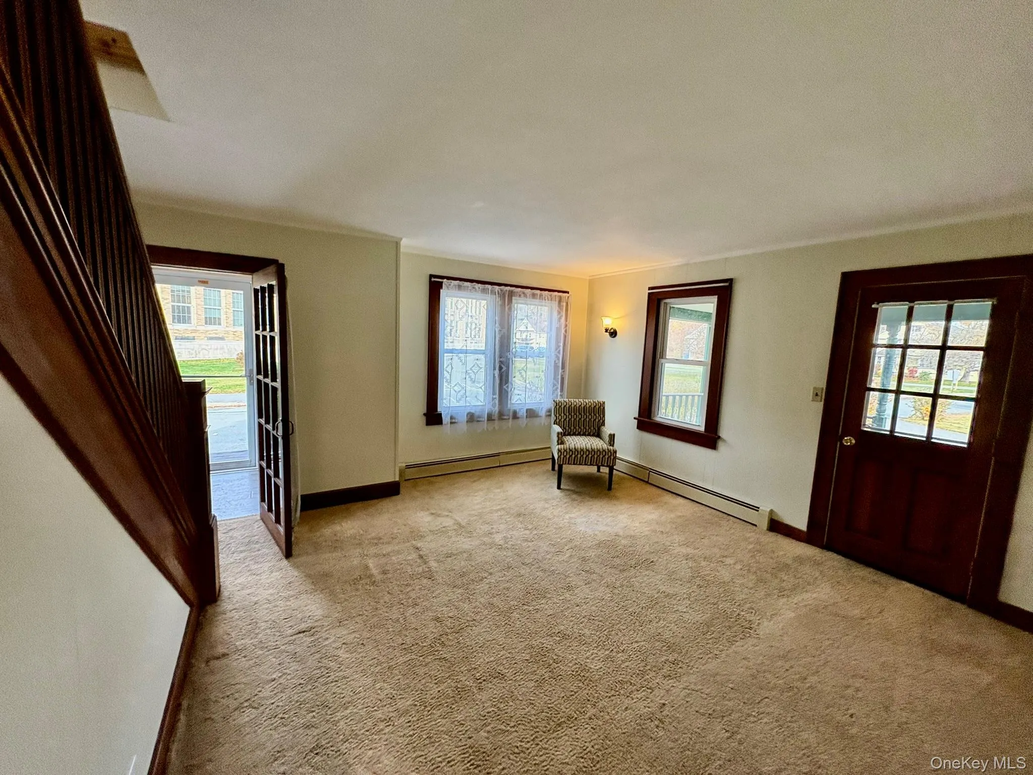 Unfurnished room featuring healthy amount of natural light, carpet flooring, a baseboard heating unit, and crown molding Unfurnished room featuring healthy amount of natural light, carpet flooring, a baseboard heating unit, and crown molding