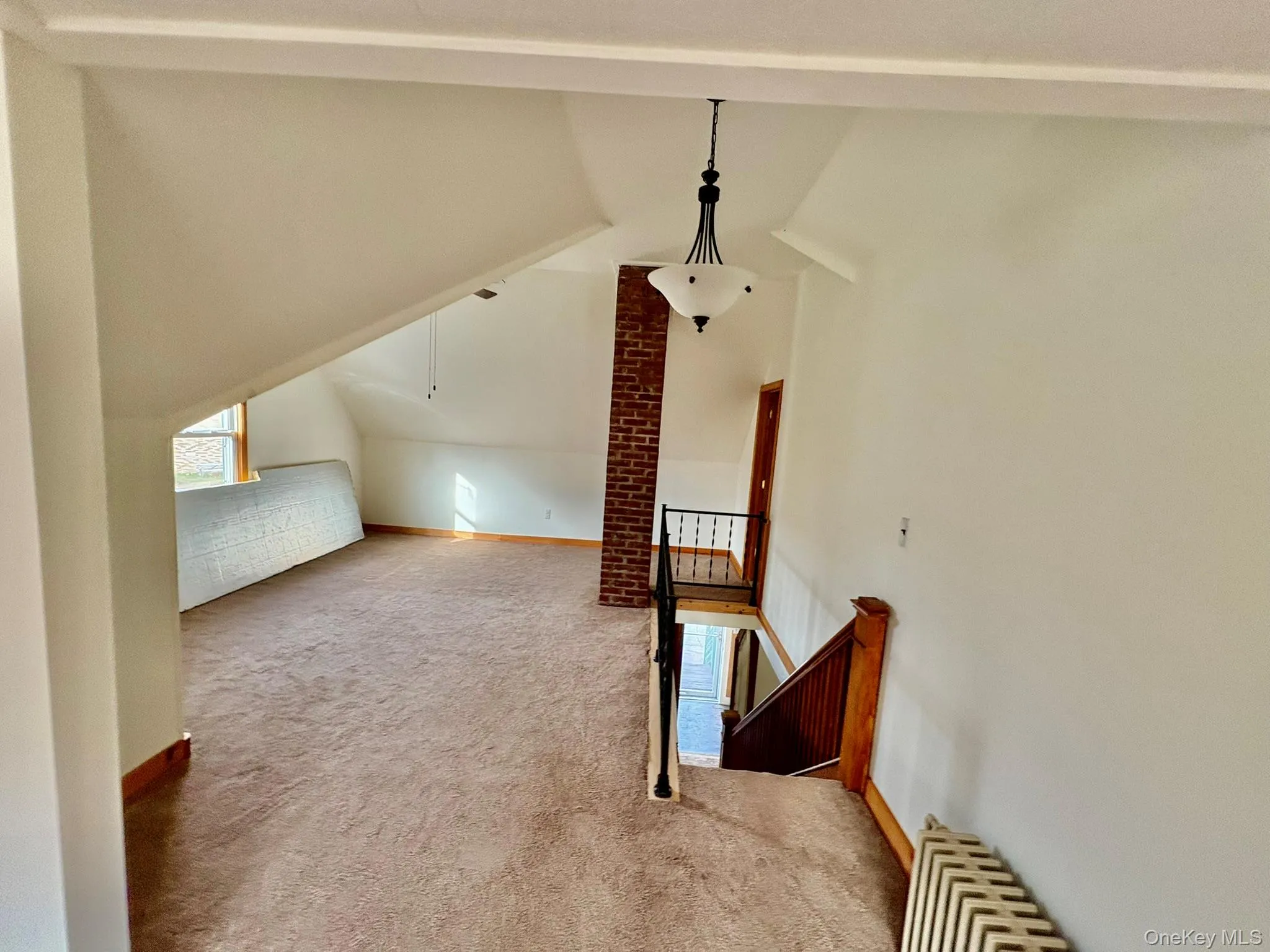 Additional living space with light carpet and radiator Additional living space with light carpet and radiator