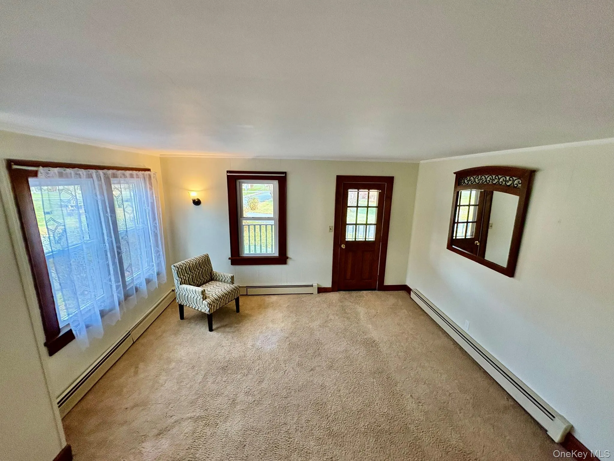 Carpeted foyer entrance with baseboard heating and crown molding Carpeted foyer entrance with baseboard heating and crown molding