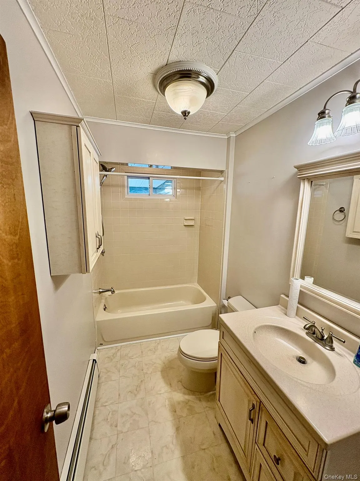 Bathroom featuring vanity, a baseboard radiator, and bathing tub / shower combination Bathroom featuring vanity, a baseboard radiator, and bathing tub / shower combination