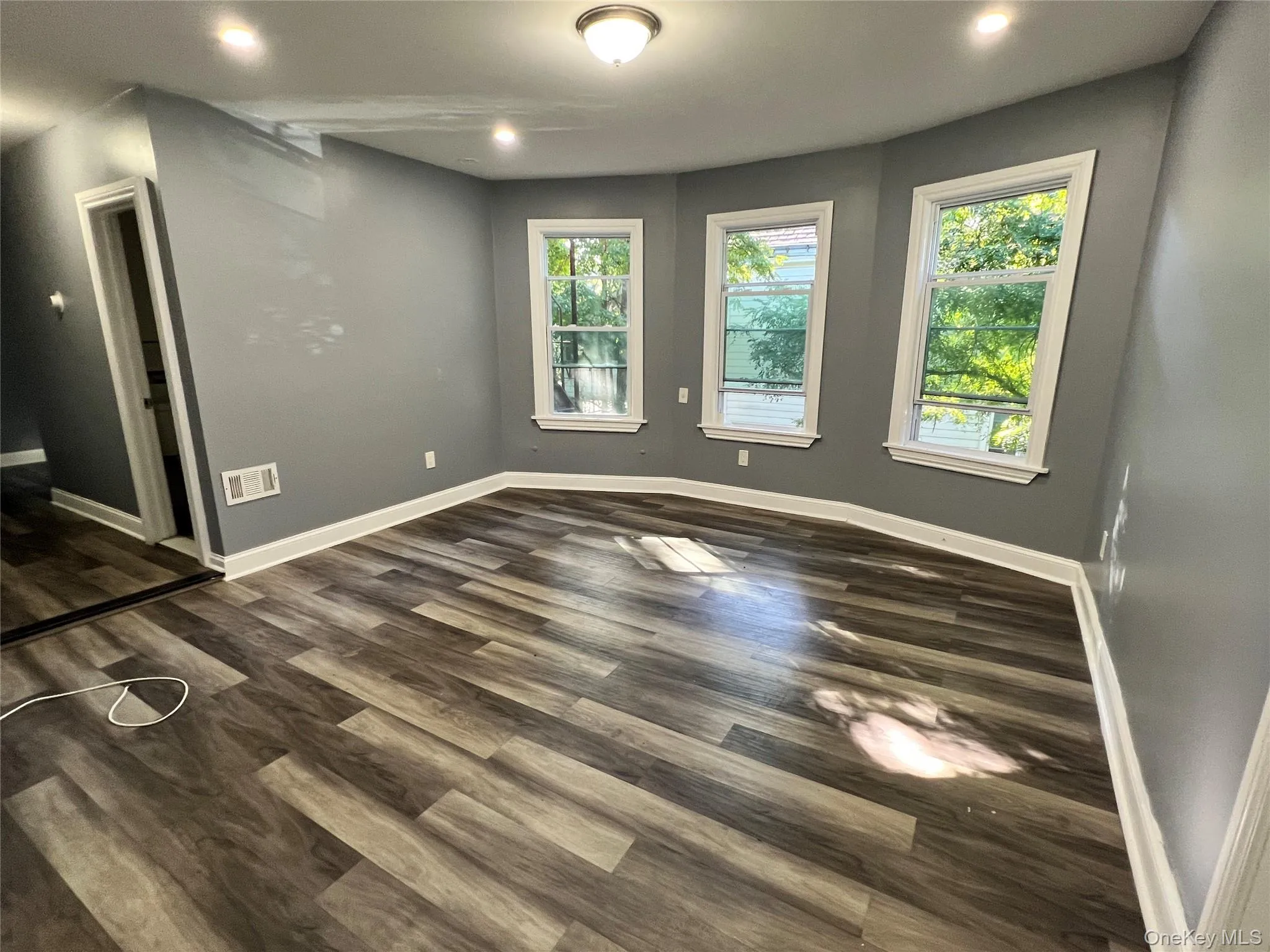 Spare room featuring dark wood-style flooring and recessed lighting Spare room featuring dark wood-style flooring and recessed lighting