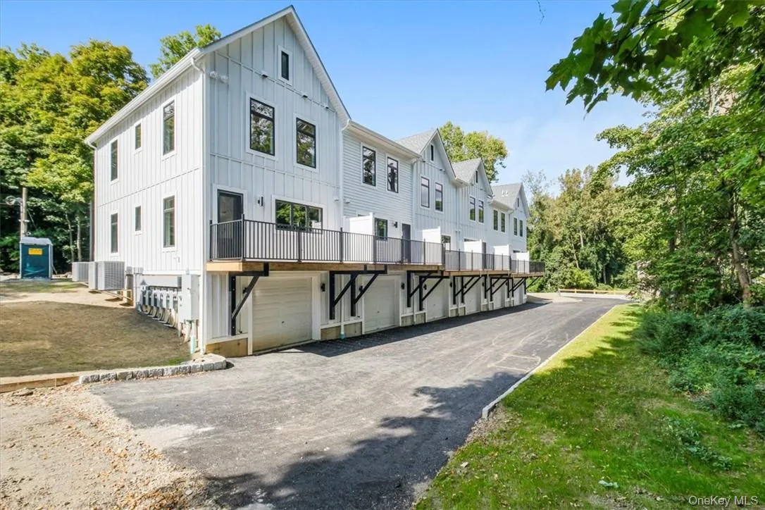Rear view of house with one car garage for each unit. Rear view of house with one car garage for each unit.