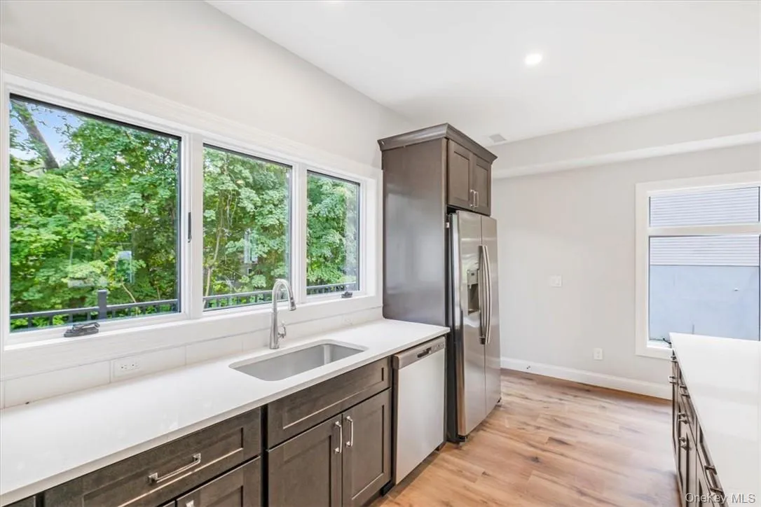 Kitchen with light hardwood / wood-style flooring, stainless steel appliances, a healthy amount of sunlight, and sink Kitchen with light hardwood / wood-style flooring, stainless steel appliances, a healthy amount of sunlight, and sink