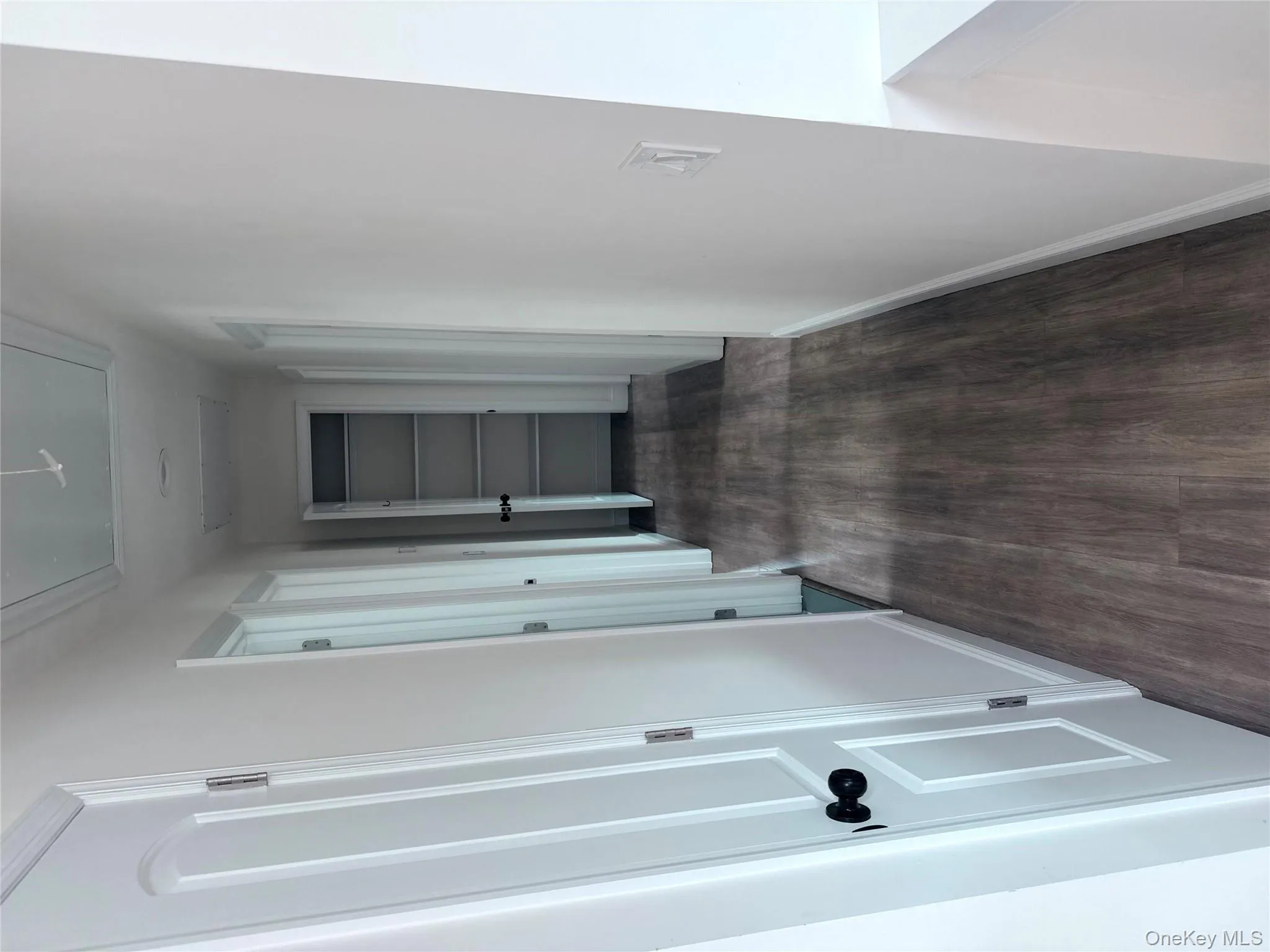 Hall featuring dark wood finished floors and attic access Hall featuring dark wood finished floors and attic access