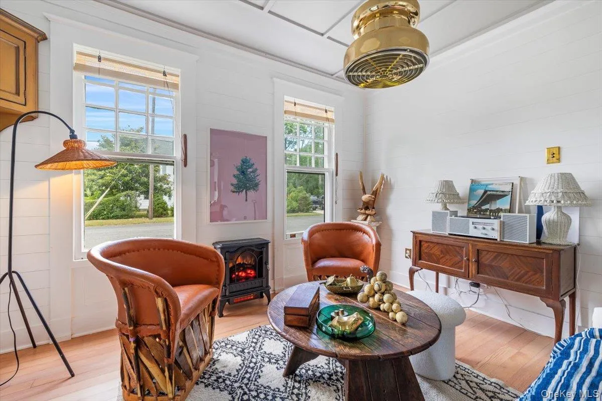 Living area featuring a wood stove and wood finished floors Living area featuring a wood stove and wood finished floors