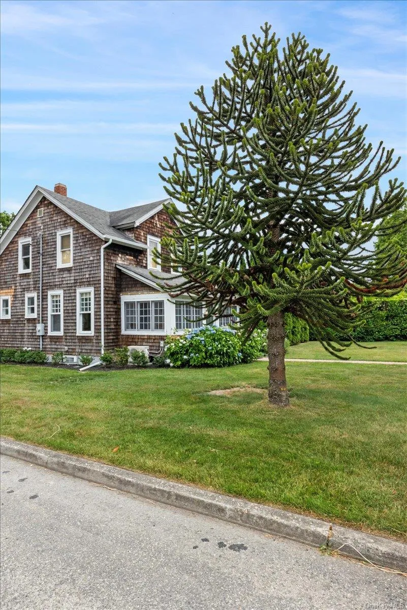 View of front facade with a front yard, a chimney, and roof with shingles View of front facade with a front yard, a chimney, and roof with shingles