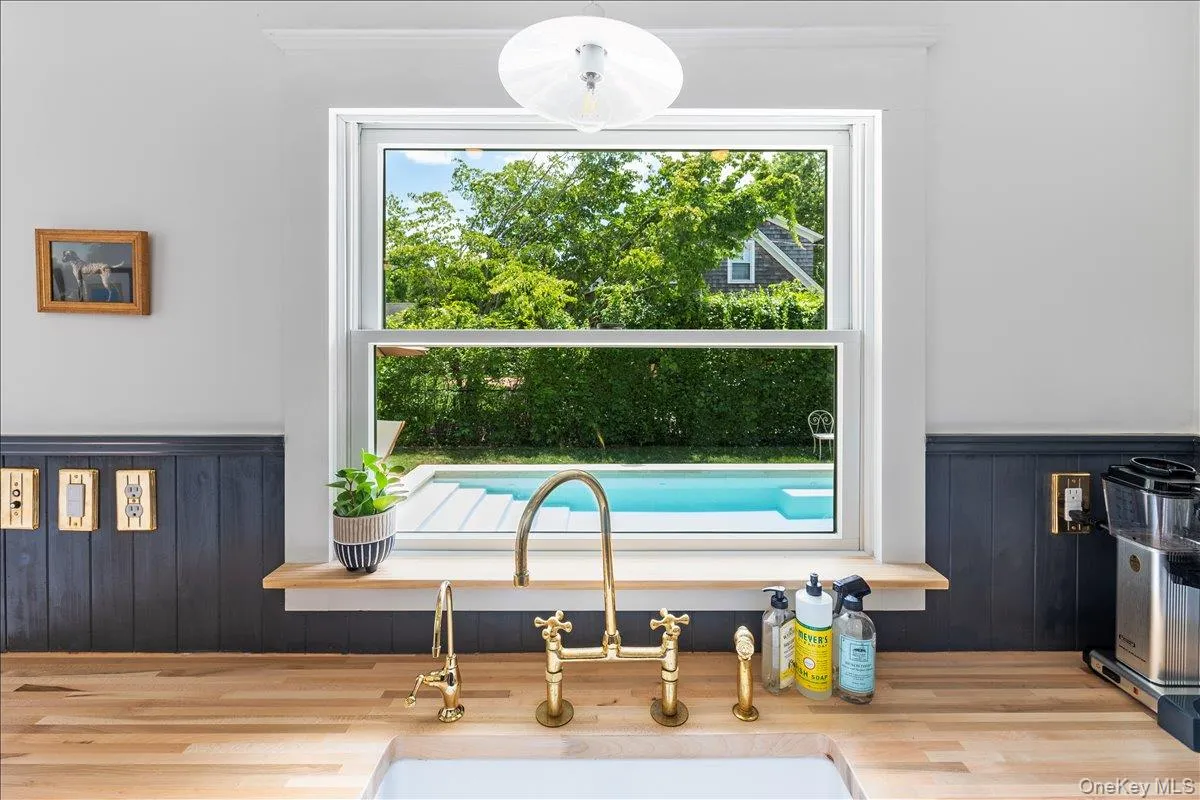 Kitchen view of a wainscoted wall, wood walls, and hanging light fixtures Kitchen view of a wainscoted wall, wood walls, and hanging light fixtures