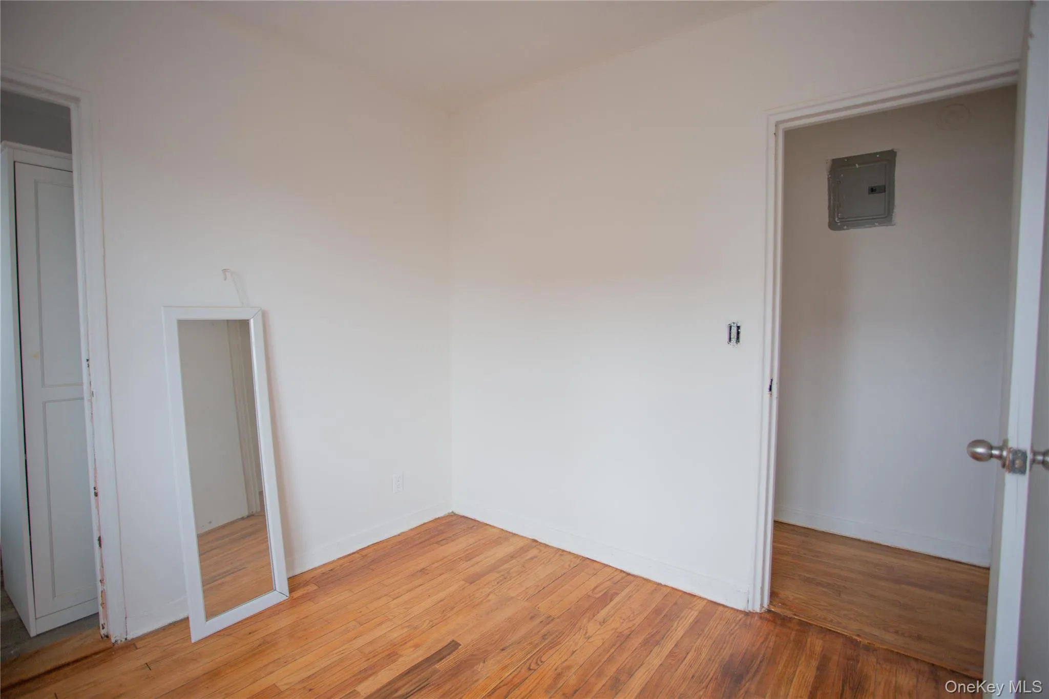 Empty room featuring light wood finished floors and electric panel Empty room featuring light wood finished floors and electric panel