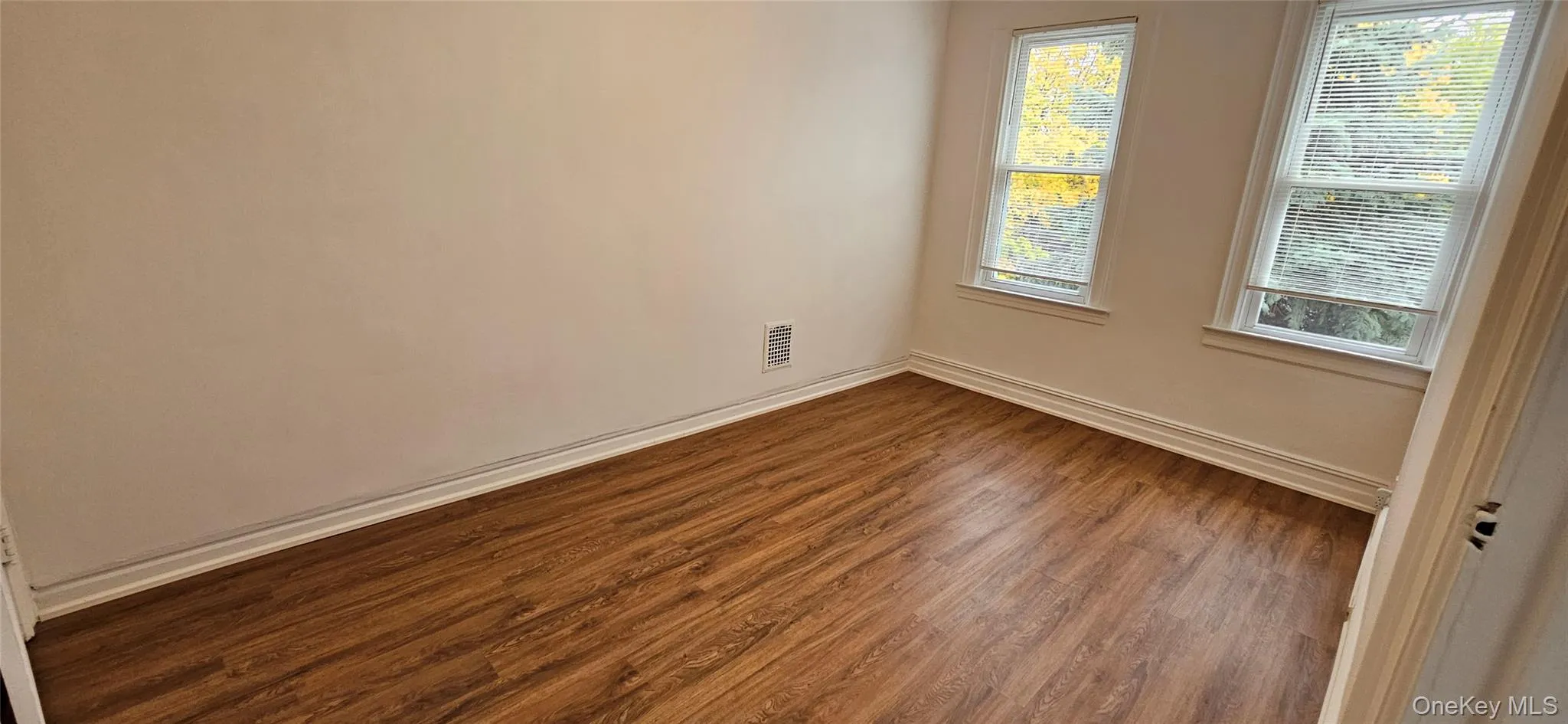 Empty room featuring wood finished floors and baseboards Empty room featuring wood finished floors and baseboards