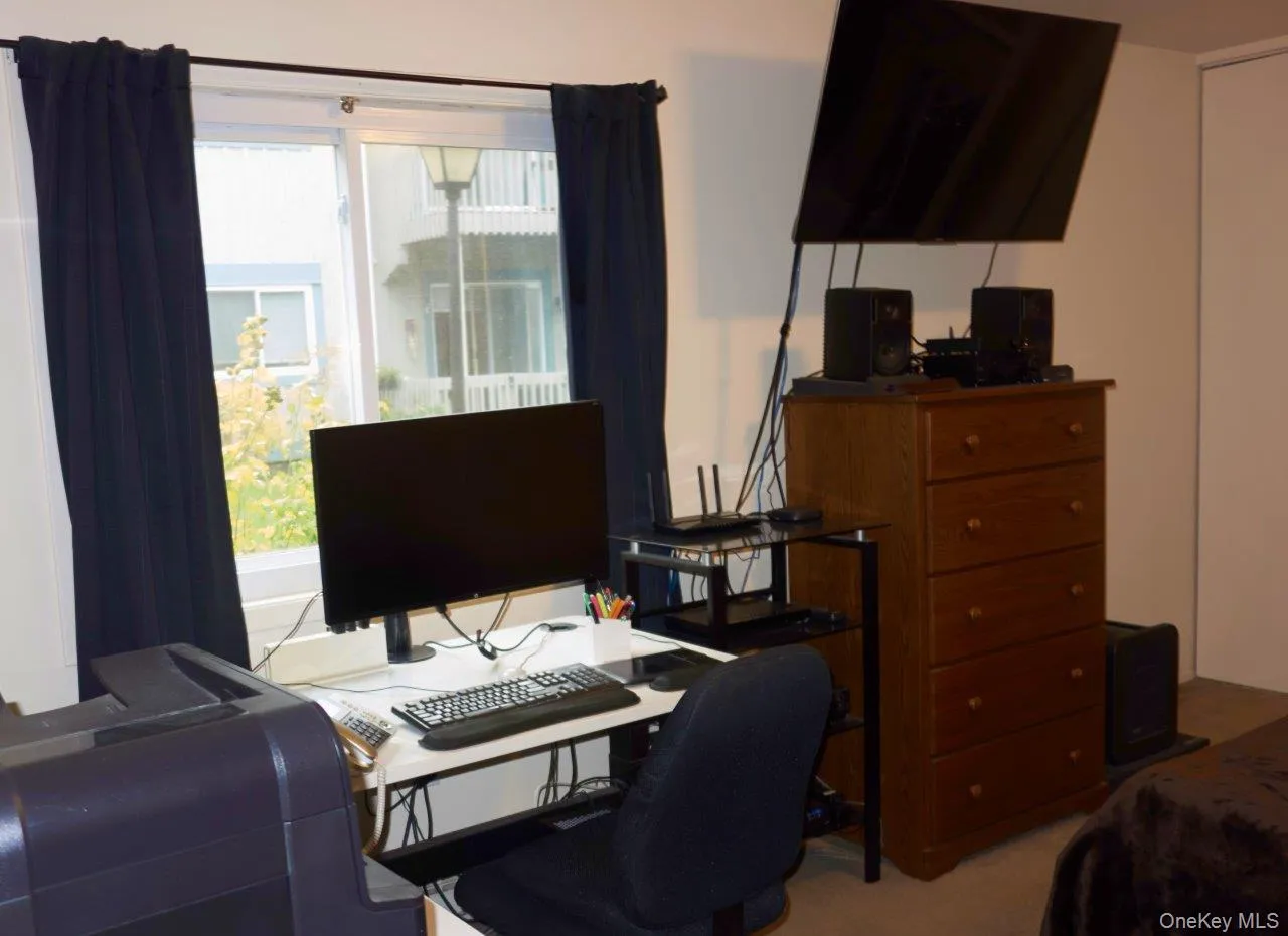 Bedroom with a desk and light colored carpet Bedroom with a desk and light colored carpet