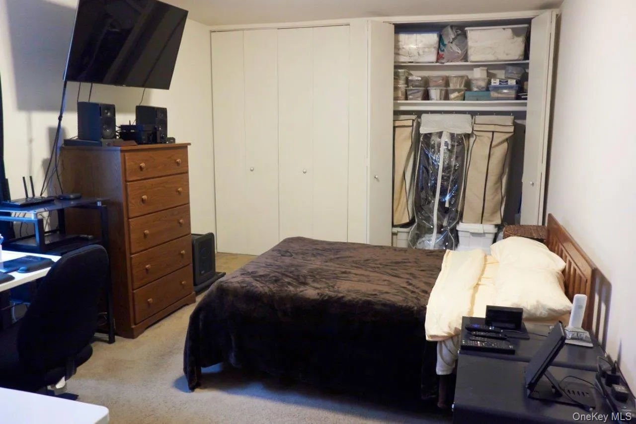 Bedroom with light carpet, an office area, and a closet Bedroom with light carpet, an office area, and a closet