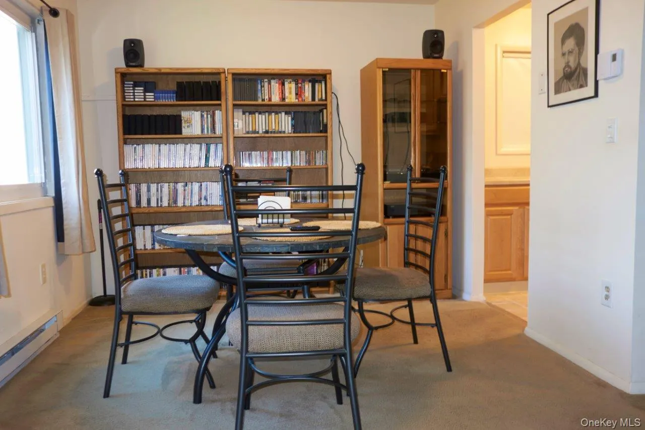 Dining area with a baseboard heating unit and light carpet Dining area with a baseboard heating unit and light carpet