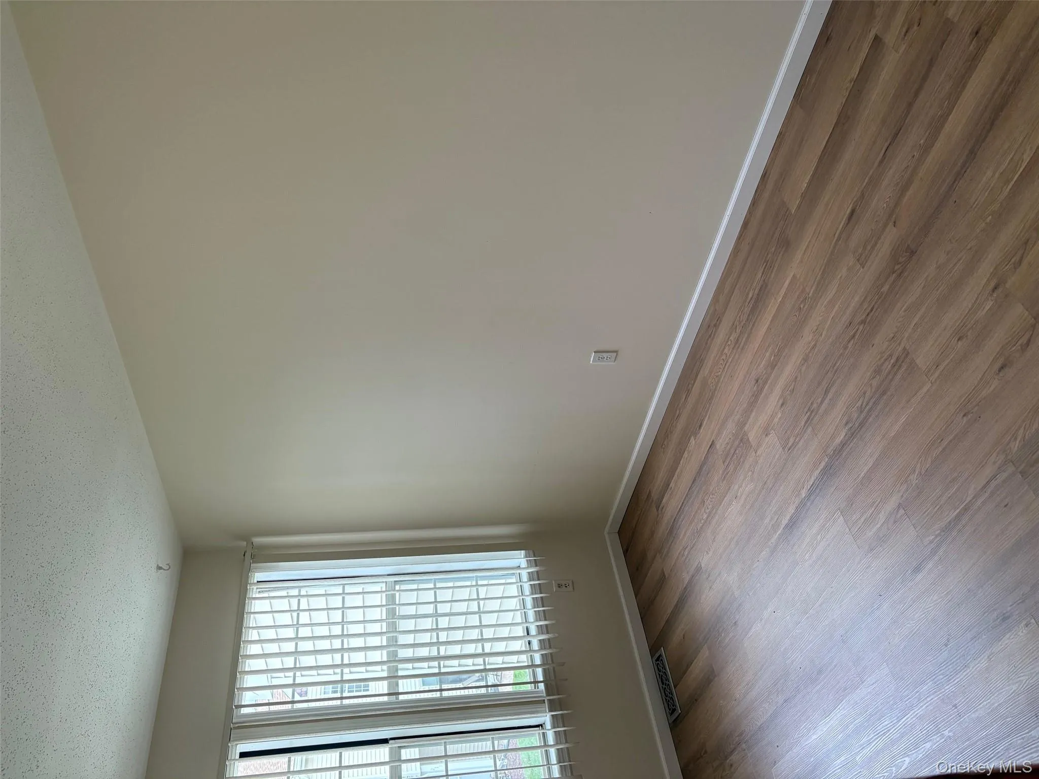 Empty room with wood finished floors and a textured ceiling Empty room with wood finished floors and a textured ceiling