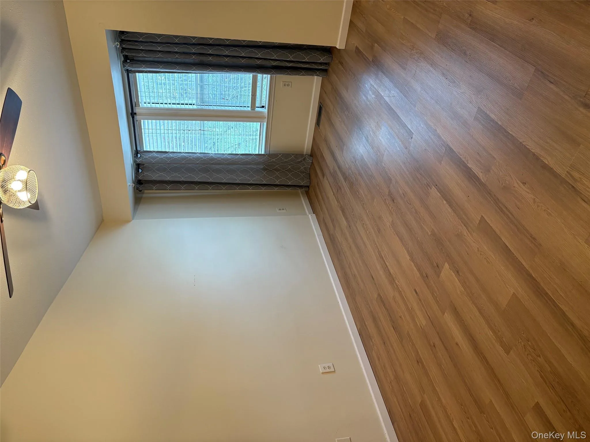 Empty room with a ceiling fan and wood finished floors Empty room with a ceiling fan and wood finished floors
