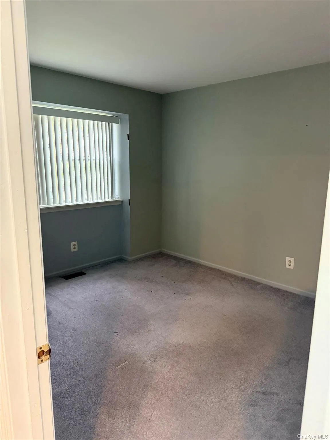 Unfurnished room with carpet flooring and baseboards Unfurnished room with carpet flooring and baseboards