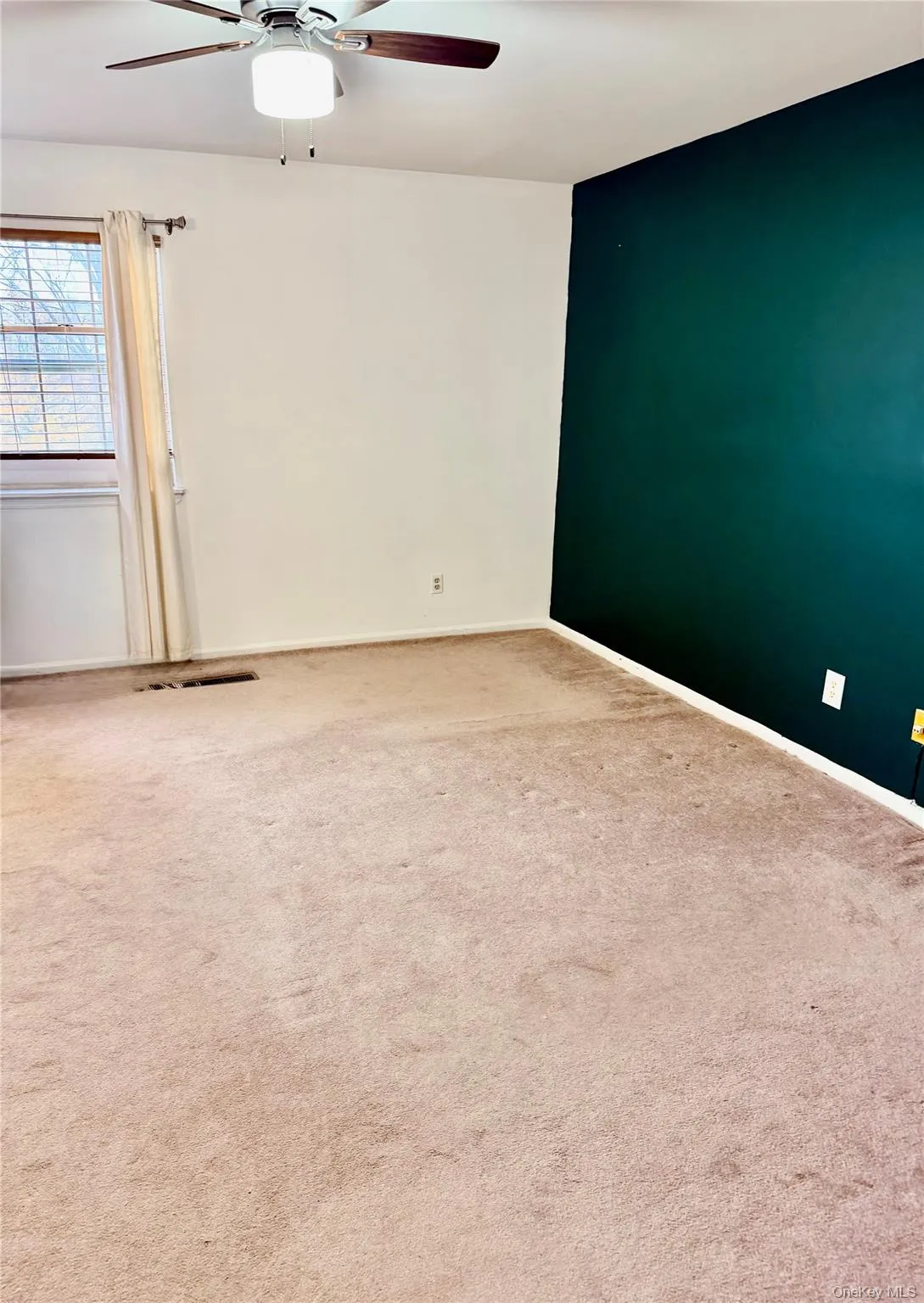 Empty room featuring carpet flooring and ceiling fan Empty room featuring carpet flooring and ceiling fan