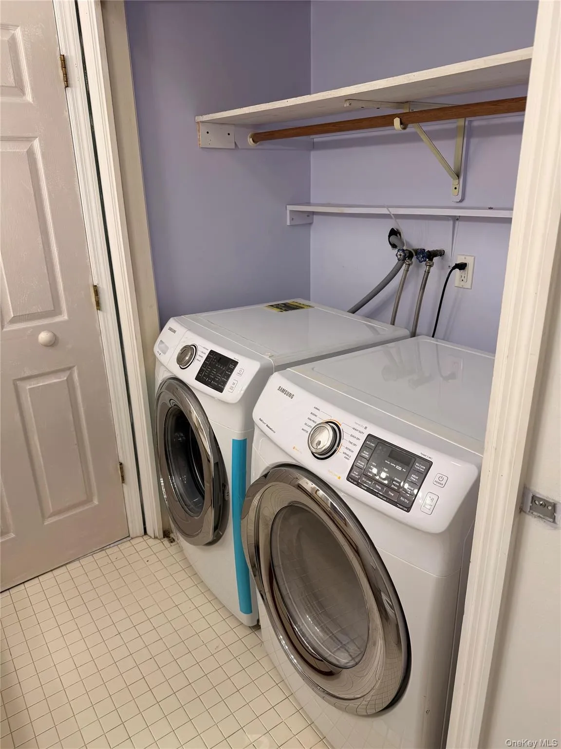 Washroom with light tile patterned flooring and washer and dryer Washroom with light tile patterned flooring and washer and dryer