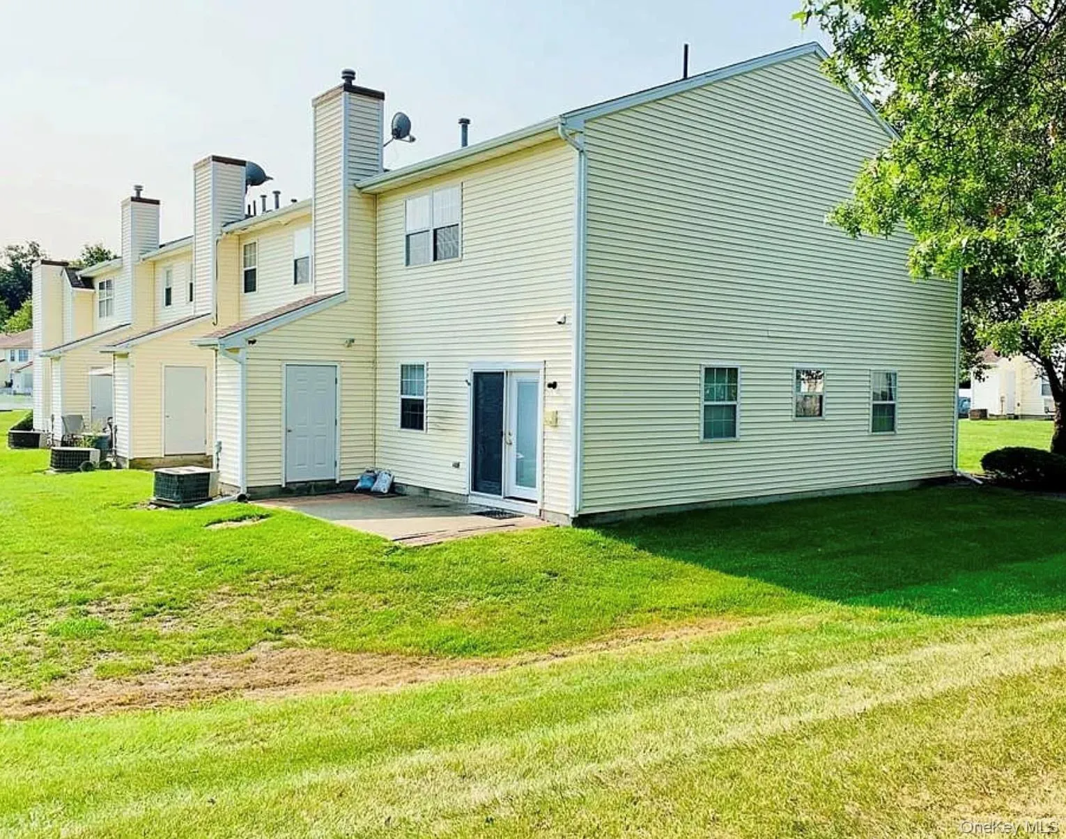 Rear view of property featuring a patio area, a yard, a chimney, and a residential view Rear view of property featuring a patio area, a yard, a chimney, and a residential view
