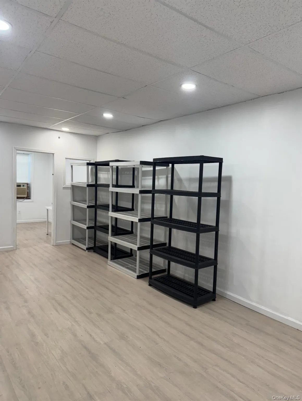 Below grade area featuring a paneled ceiling, light wood-type flooring, and recessed lighting Below grade area featuring a paneled ceiling, light wood-type flooring, and recessed lighting