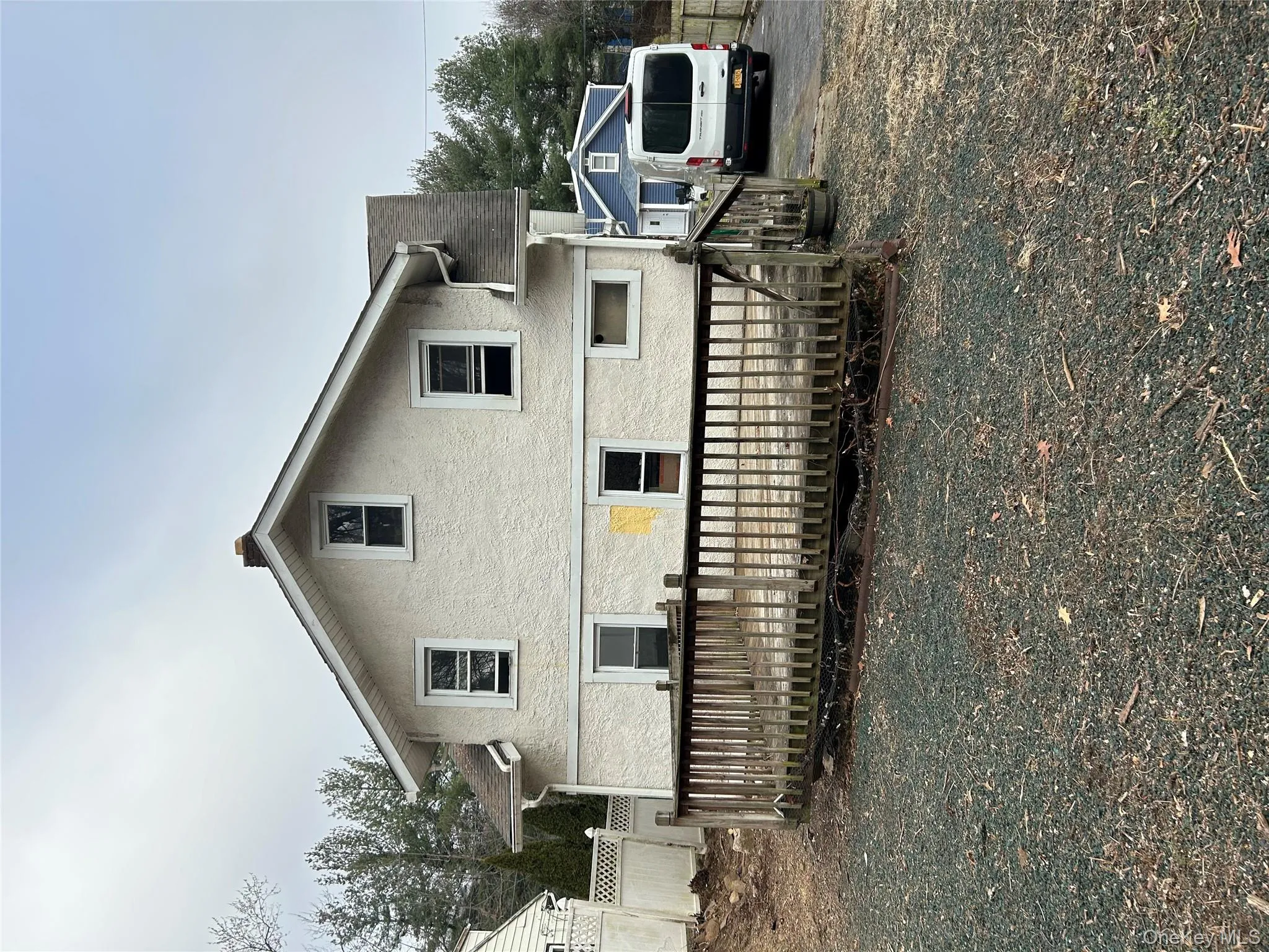 Rear view of house with a wooden deck and stucco siding Rear view of house with a wooden deck and stucco siding