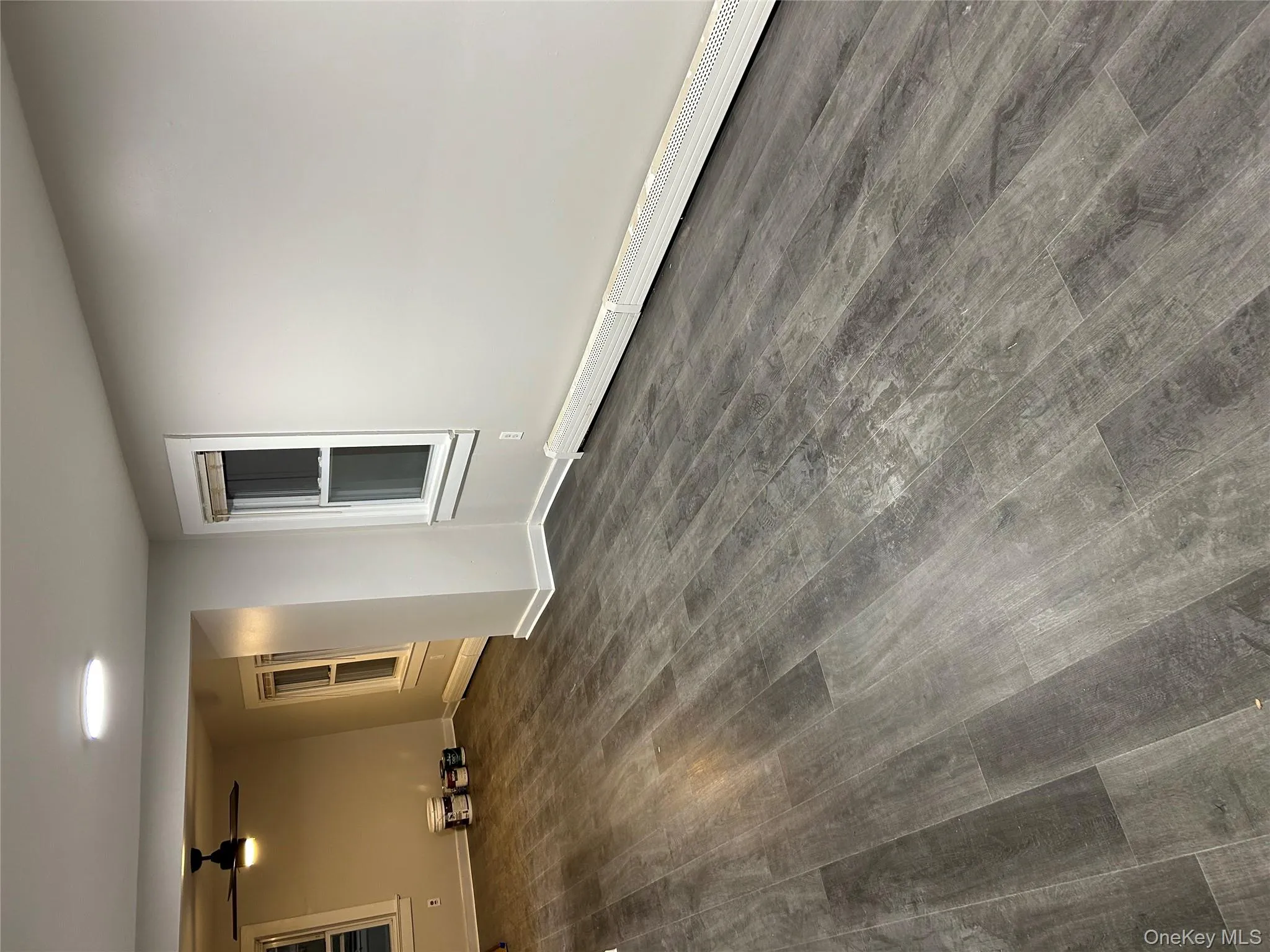Empty room featuring a baseboard heating unit, dark wood finished floors, and ceiling fan Empty room featuring a baseboard heating unit, dark wood finished floors, and ceiling fan