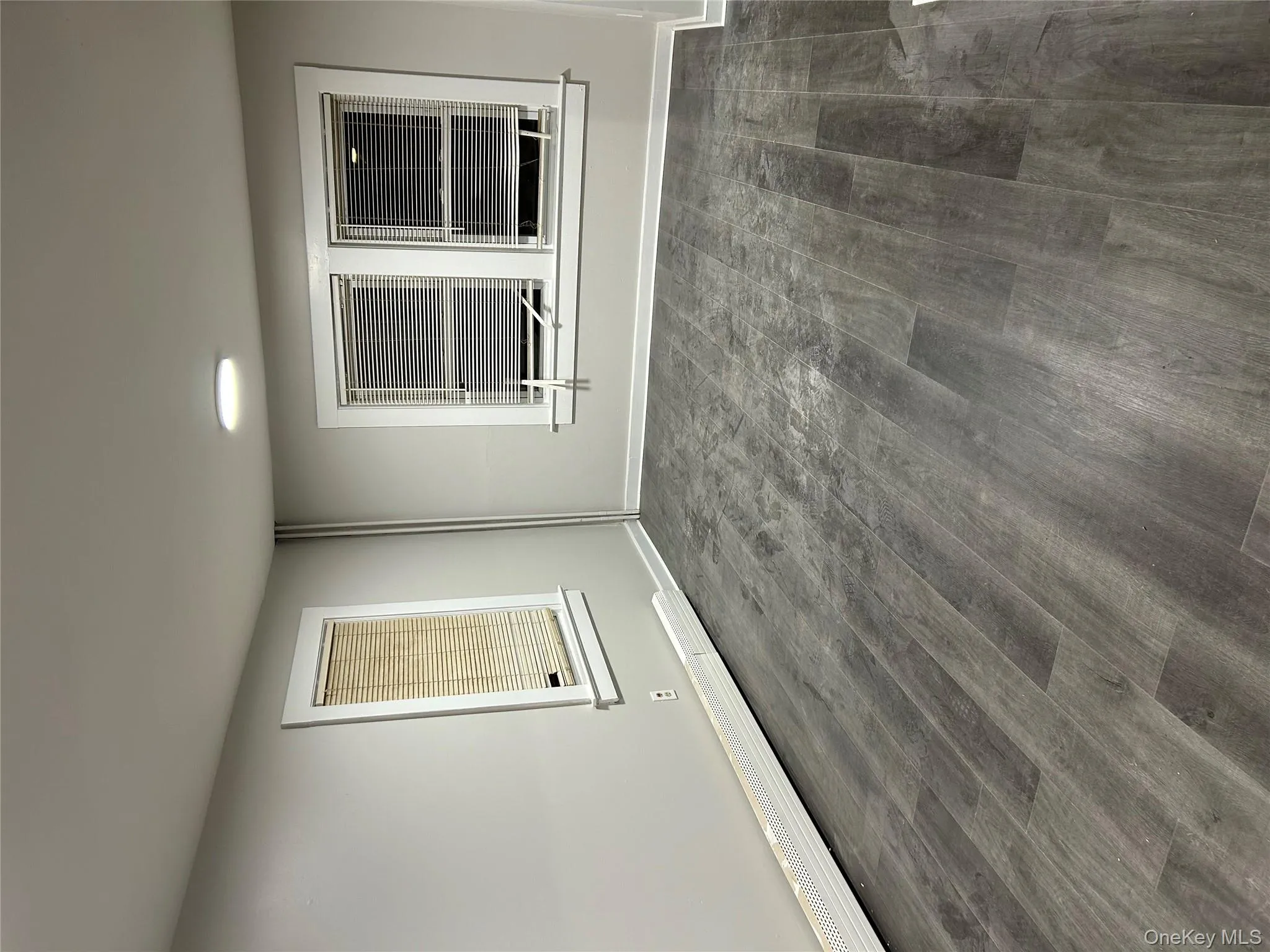 Empty room with baseboard heating and dark wood-type flooring Empty room with baseboard heating and dark wood-type flooring