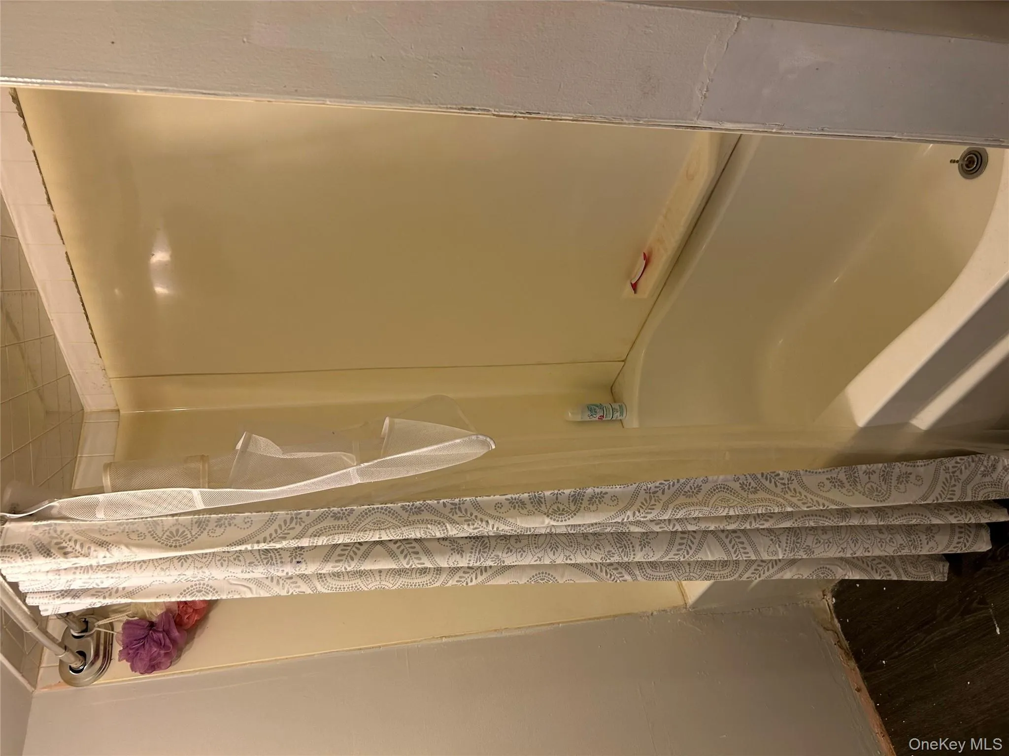 Bathroom with shower / tub combo with curtain and dark wood-style flooring Bathroom with shower / tub combo with curtain and dark wood-style flooring