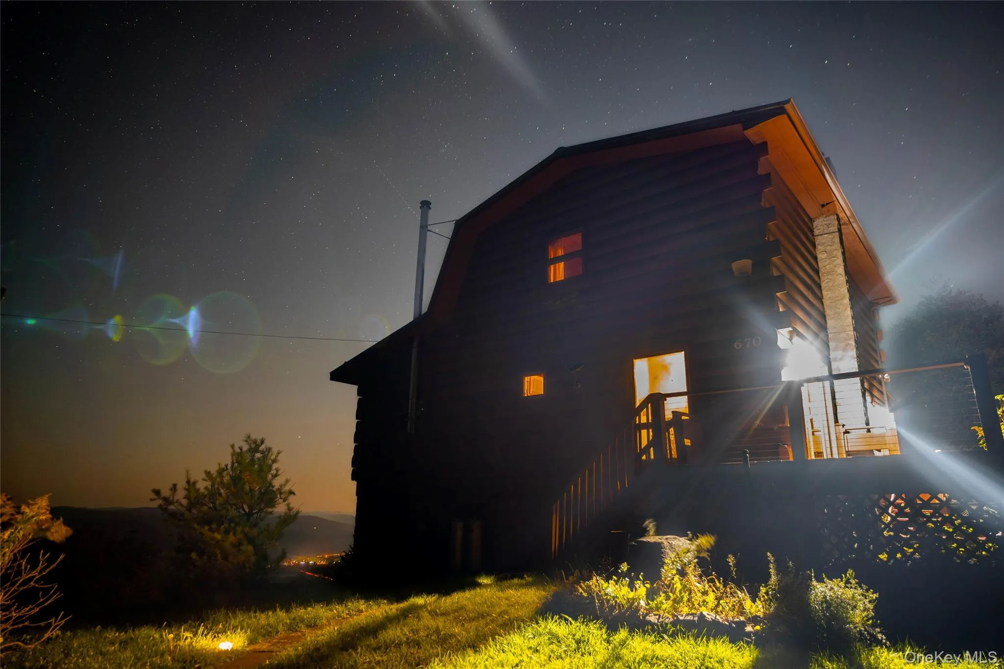 Property exterior at twilight featuring a gambrel roof and log exterior Property exterior at twilight featuring a gambrel roof and log exterior