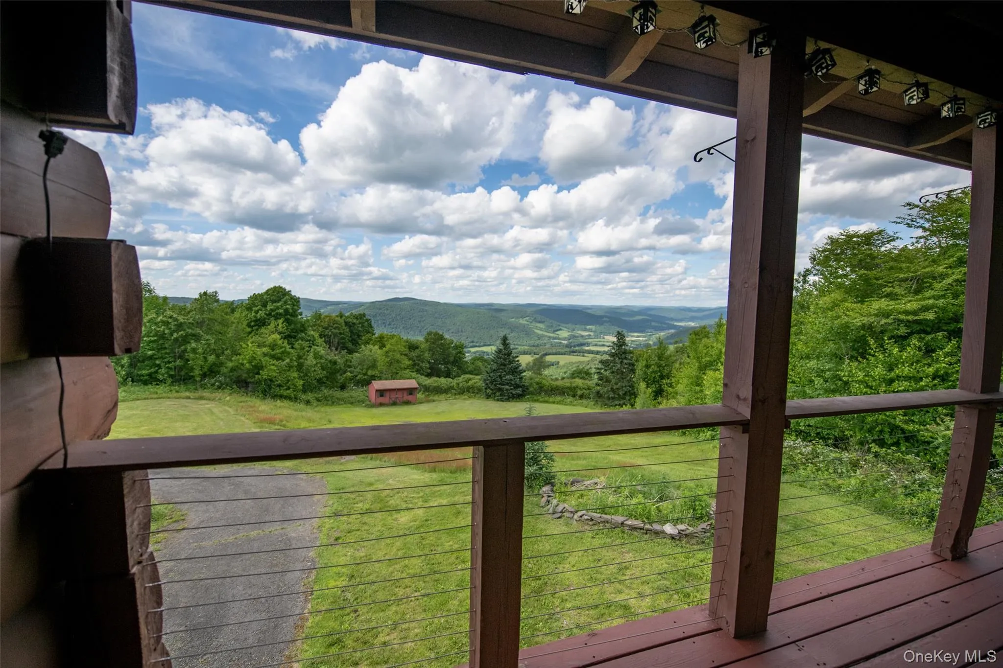 Wooden deck featuring view of wooded area and a lawn Wooden deck featuring view of wooded area and a lawn