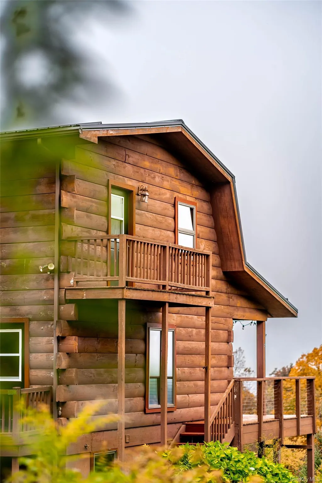 Rear view of property featuring faux log siding and a deck Rear view of property featuring faux log siding and a deck