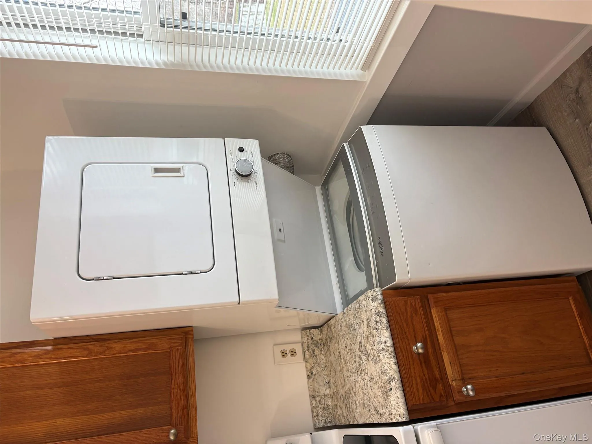 Laundry area featuring estacked washer and dryer and wood finished floors Laundry area featuring estacked washer and dryer and wood finished floors