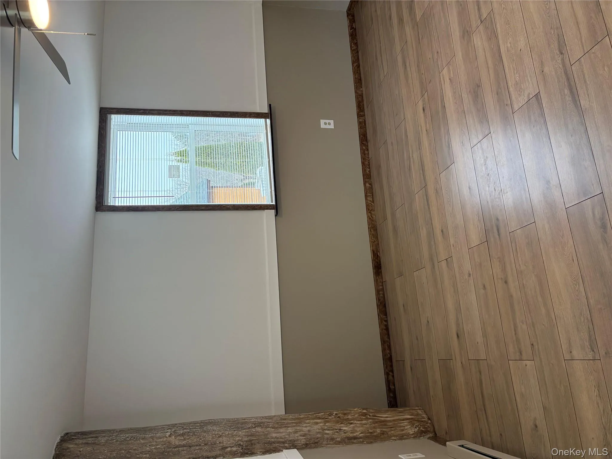 Spare room featuring light wood-style flooring, a ceiling fan, and a baseboard radiator Spare room featuring light wood-style flooring, a ceiling fan, and a baseboard radiator