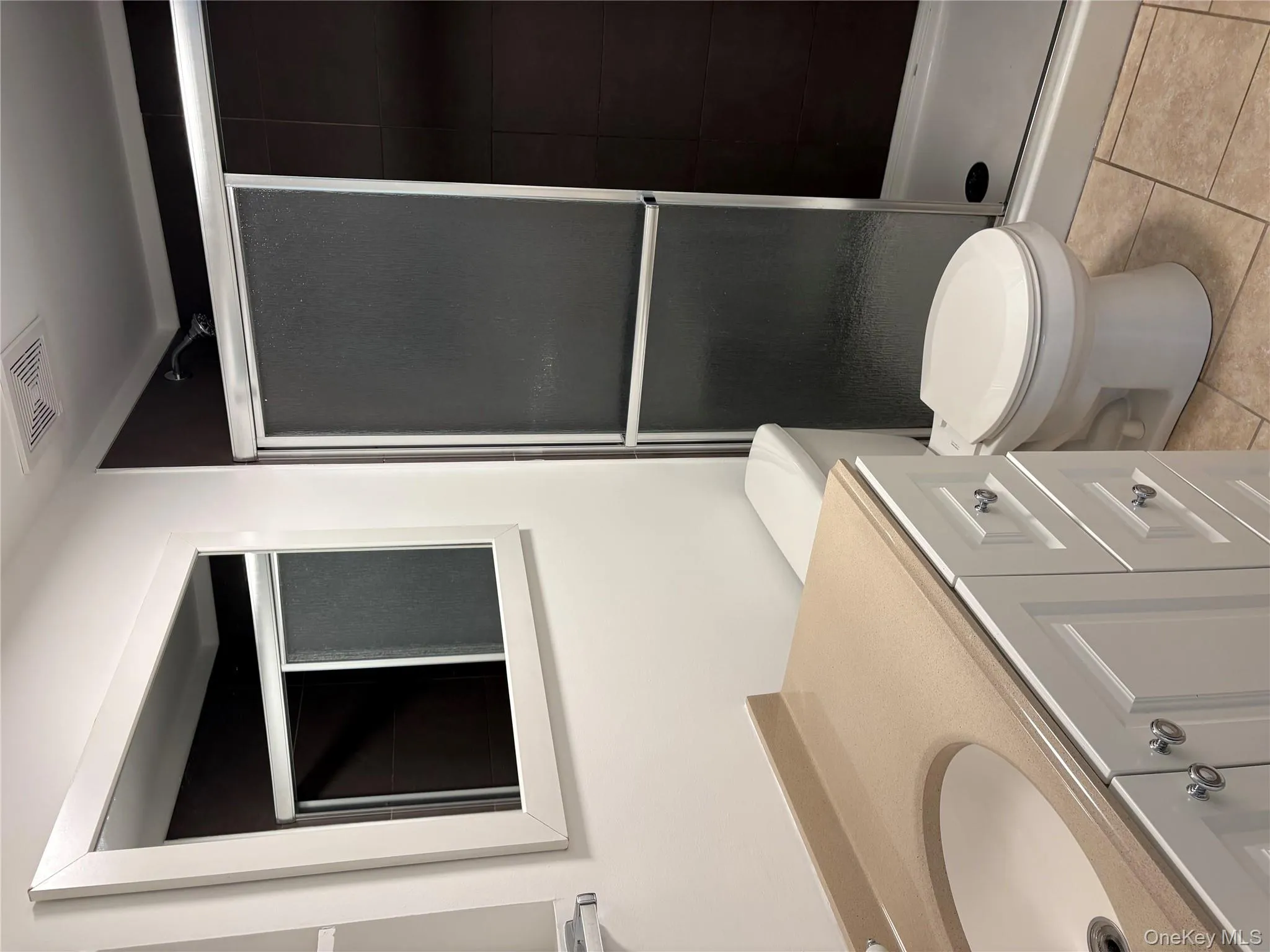 Bathroom featuring vanity, a shower stall, and light tile patterned floors Bathroom featuring vanity, a shower stall, and light tile patterned floors