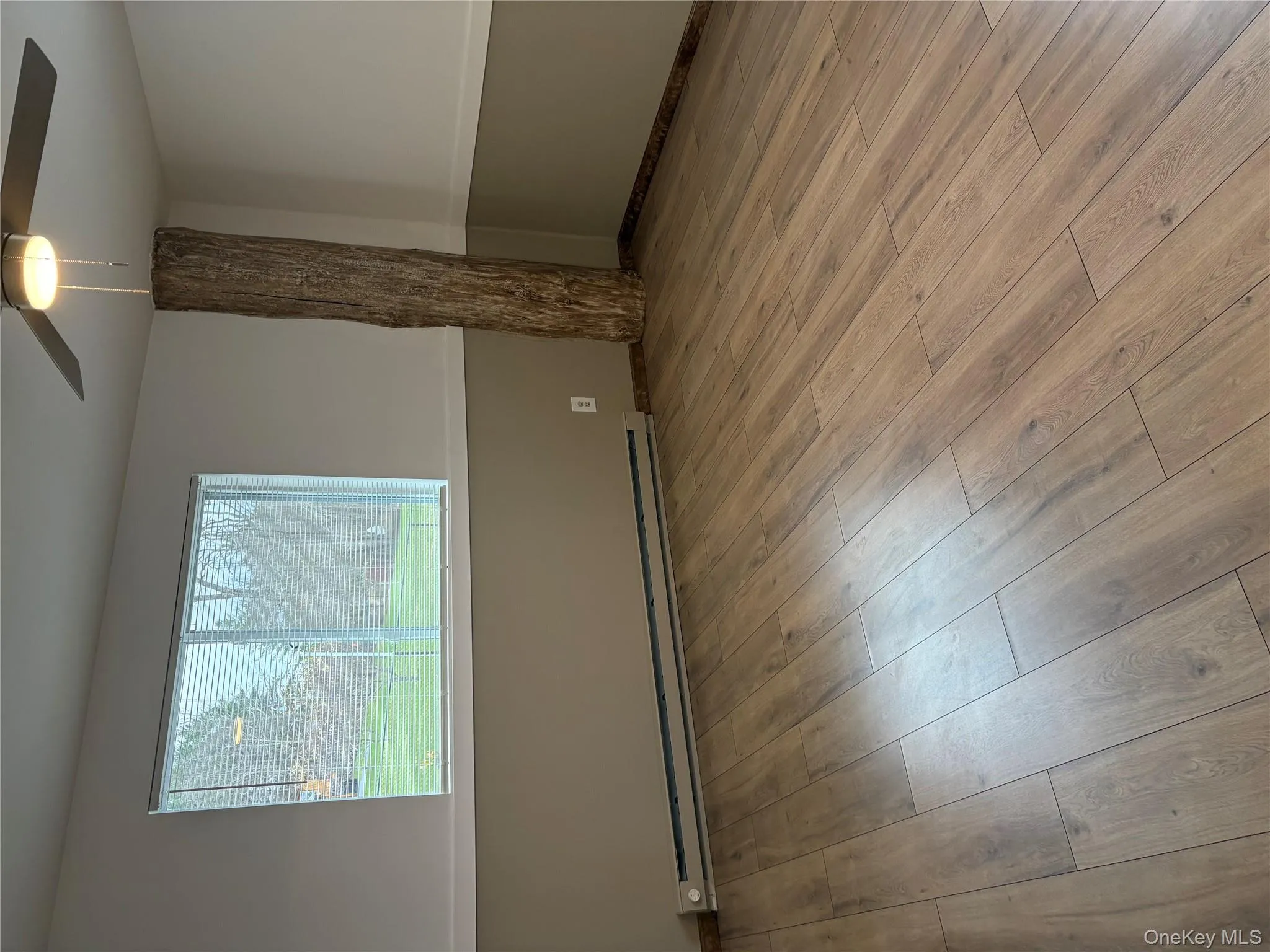 Unfurnished room featuring light wood-style flooring, baseboard heating, and a ceiling fan Unfurnished room featuring light wood-style flooring, baseboard heating, and a ceiling fan