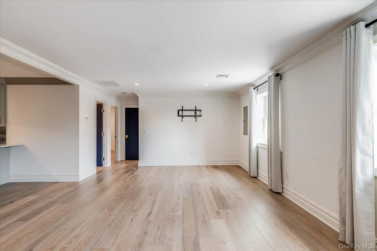 Empty room with ornamental molding, light wood finished floors, and recessed lighting Empty room with ornamental molding, light wood finished floors, and recessed lighting