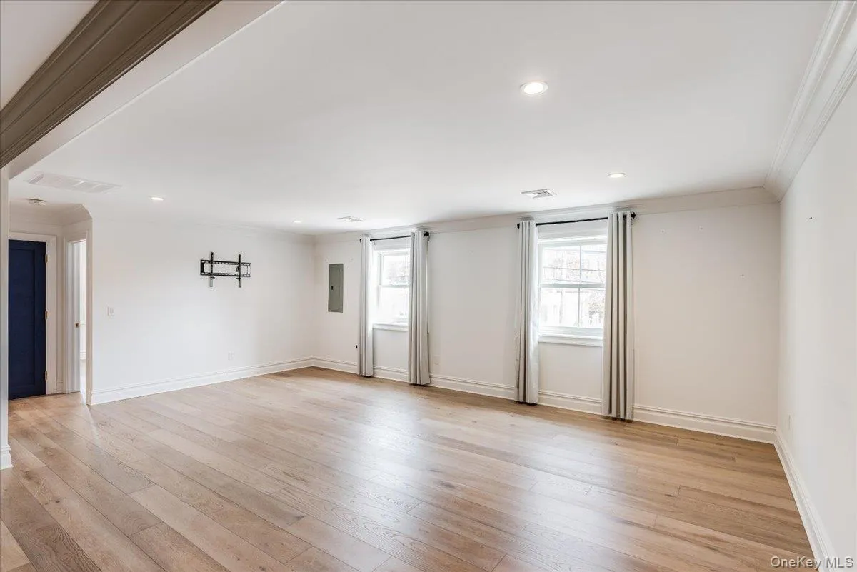 Unfurnished room featuring crown molding, light wood-style flooring, recessed lighting, and electric panel Unfurnished room featuring crown molding, light wood-style flooring, recessed lighting, and electric panel