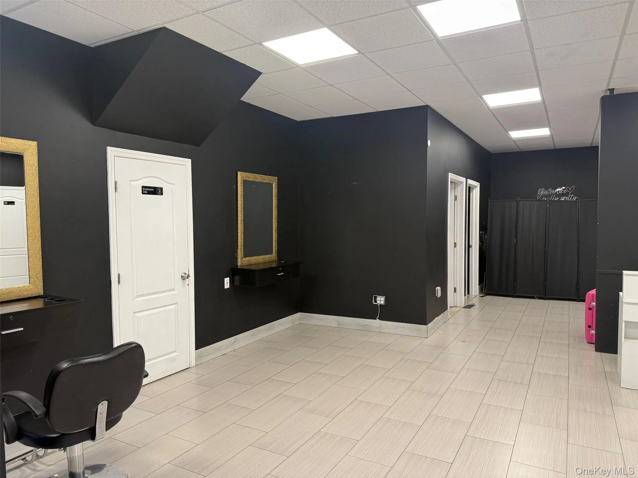 Unfurnished area featuring a drop ceiling and baseboards Unfurnished area featuring a drop ceiling and baseboards